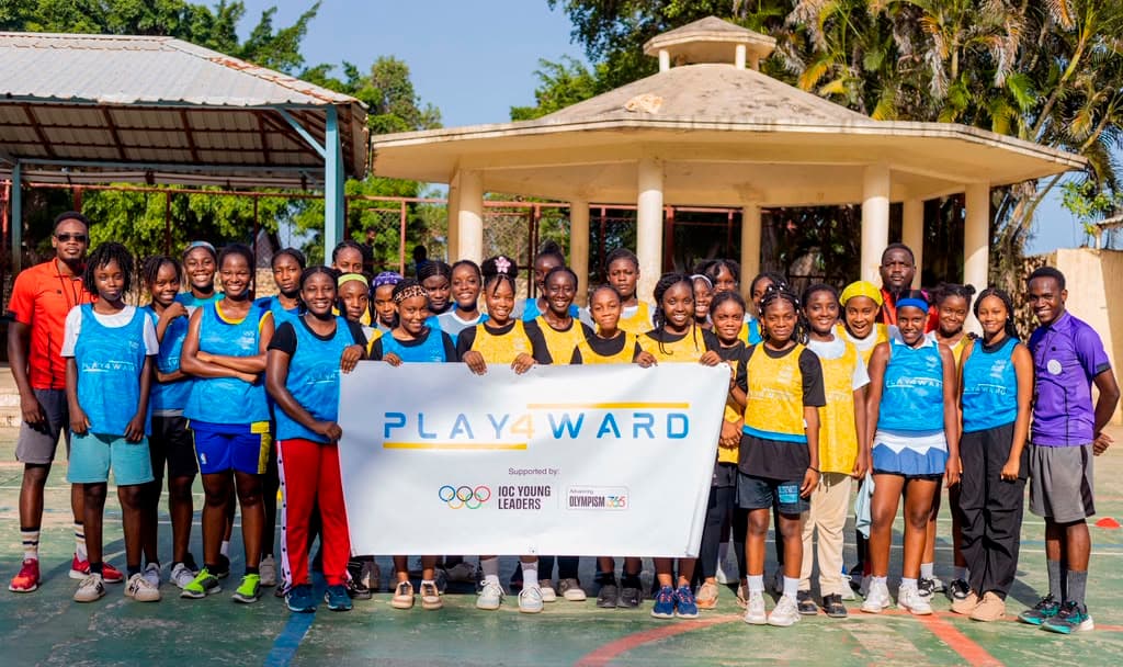 Des athlètes de PLAY4WARD tenant la bannière de l'équipe après un entraînement à Jacmel